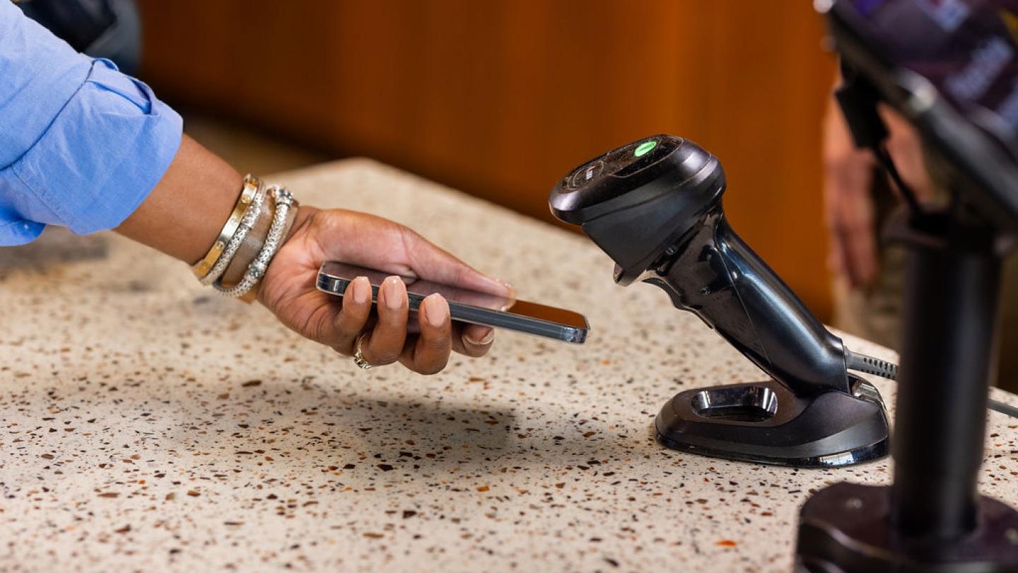 femme tenant son téléphone devant le scanner